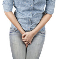 Close up of a woman with hands holding her crotch isolated in a